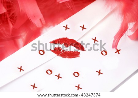 lipstick kiss on letter envelope surrounded by glamorous  red feather boa, x\'s and o\'s confetti