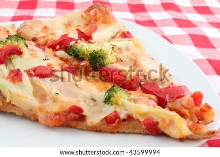 Two slices of red peppers, broccoli and grilled chicken pizza with red checkered table cloth background