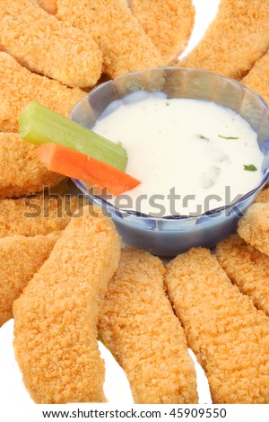 A plate of golden crispy chicken fingers with  vegetables and dip