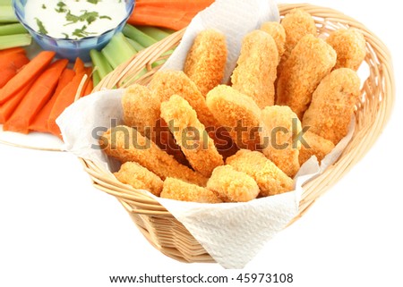 A basket of crispy chicken fingers with platter of vegetables and ranch dip on a white background