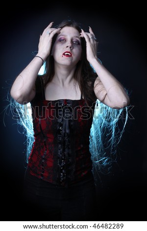 Woman vampire with long hair, fangs, claws and dripping blood from lips.