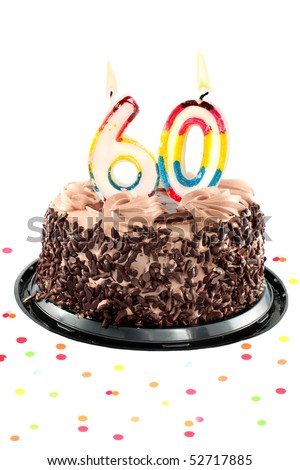Chocolate birthday cake surrounded by confetti with lit candle for a sixtieth birthday or anniversary celebration