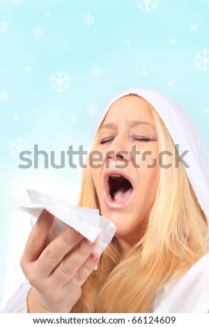 Woman with flu or cold in the snow holding a tissue ready to sneeze