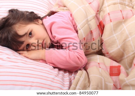 Cute little girl laying in bed and can\'t fall asleep or is just waking up