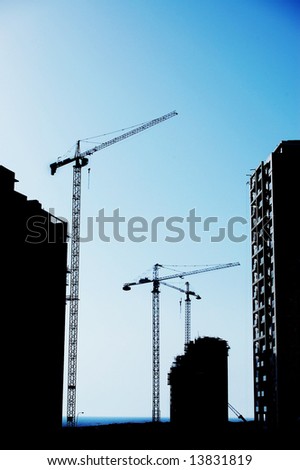 cranes on construction site silhouette