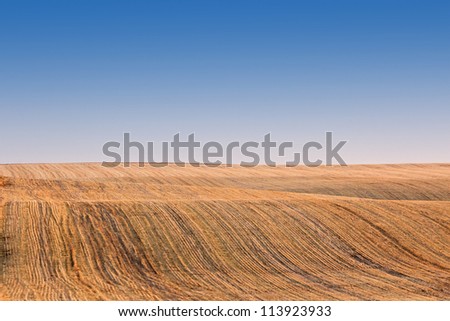 Rolling golden harvested fields under bright blue skies