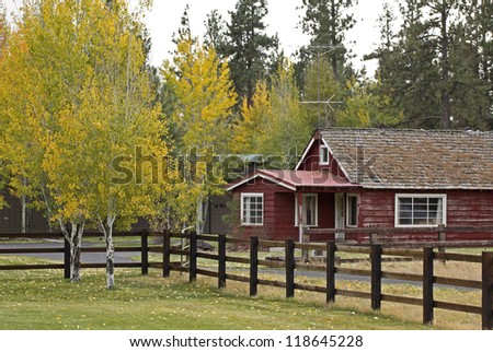 Vintage wooden red ranch house with autumn foliage