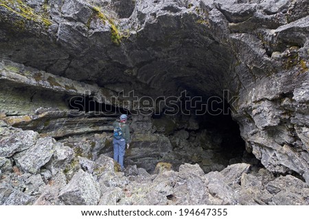 Lone Female Caver At Entrance To Large Lava Tube Cave
