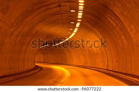 Lighted Concrete Highway Tunnel-A lighted highway tunnel going through a mountain.