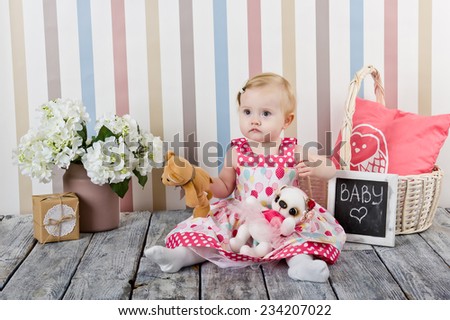 Cute girl in dress sitting on the floor among the flowers and interior items