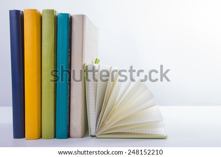 A stack of colorful books and open book. Ideas for business and self-development isolated on white background with empty place for your text