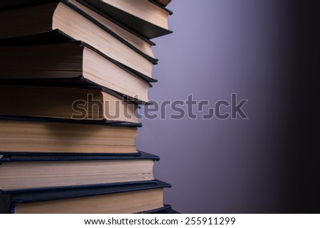 Books stacking. Back to school. Purple background.