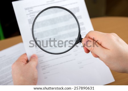 Signing papers. Lawyer, realtor, businessman sign documents, looking through the magnifying glass, search information.