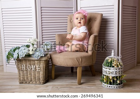 Little girl sitting on the chair at home