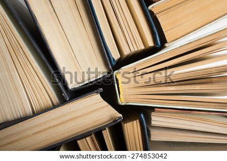 Top view of old used hardback books. Open book, fanned pages. Back to school. Reading are essential for self improvement, gaining knowledge and success in our careers, business and personal lives.