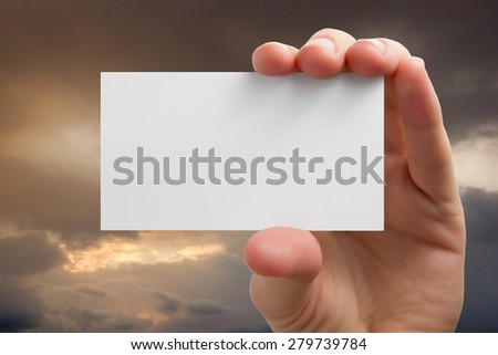 Hands holding a white business visit card, gift, ticket, pass, present closeup on sky background. Copy space.