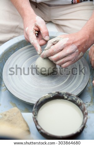 Pottery. Hand made ware. Hands working on pottery wheel. Potter working at his workshop
