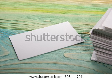 White blank corporate identity package business visit card, gift, ticket, pass, present close up on blue green wooden background