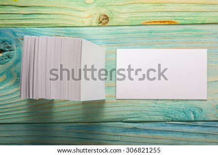 White blank business visit card, gift, ticket, pass, present close up on blue green wooden background. Copy space. Blank corporate identity package business card Template for ID. Mock-up card.
