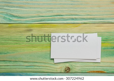 White blank business visit card, gift, ticket, pass, present close up on blue green wooden background. Copy space. Blank corporate identity package business card Template for ID. Mock-up card.