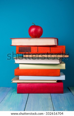 Composition with vintage old hardback books, diary, fanned pages on blue wooden deck table background. Books stacking. Back to school. Copy Space. Education background.