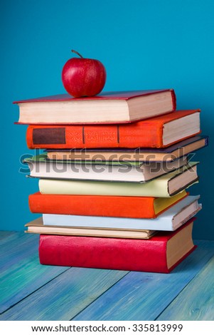Stack of books, grungy blue background, free copy space Vintage old hardback books on wooden shelf on the deck table, no labels, blank spine. Back to school. Education background