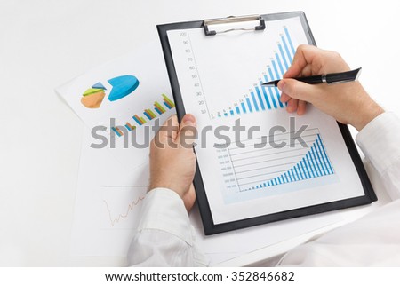 Businessman counting losses and profit working with statistics, analyzing financial the results.