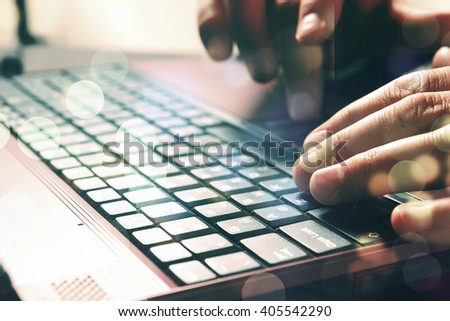 Man\'s hands typing on laptop keyboard. Double expo