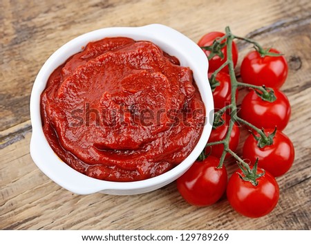 Tomatoes  paste with ripe tomatoes on wooden tables