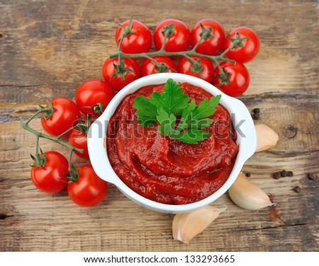 Tomatoes paste with ripe tomatoes on wooden tables