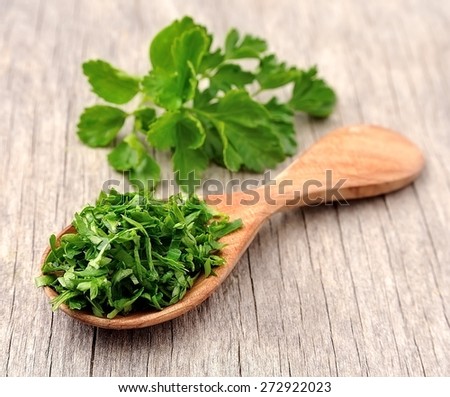 Fresh parsley herbs on wooden texture. Chopped greens