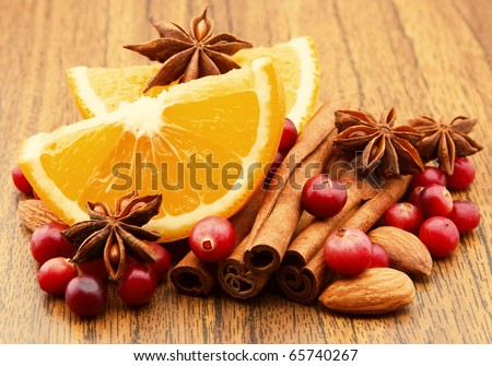 Lobes of an orange with cinnamon, an anise and a cranberry closeup