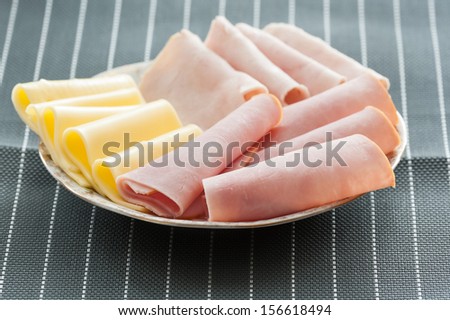 Slices of ham and cheese on plate