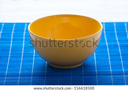 yellow bowl on the blue pad - stock photo