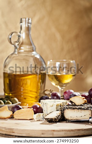 Various cheeses on the board and grapes