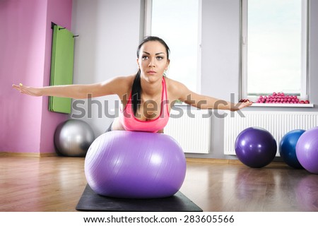 Young woman doing fitness exercises with fit ball