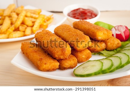 fish sticks with vegetables on a white plate