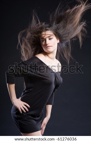 a girl with a wind in hair in black dress