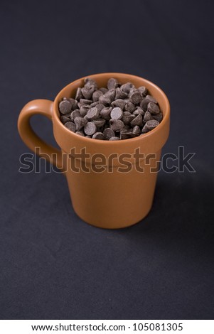 Vegan Chocolate Chips in Terracotta Cup with Black Background