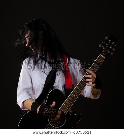 young girl with a guitar, on black background