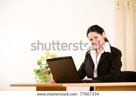 young beautiful businesswoman sitting with laptop in office