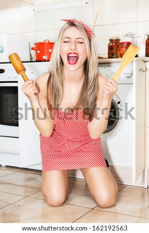 Beautiful young housewife in the kitchen. Woman in pin up style.