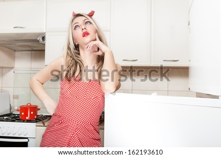Young woman in front of the fridge. Woman in pin up style.
