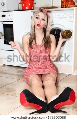 Woman in the kitchen preparing food for the holiday. Woman in kitchen holding a glass jar of tomatoes in the hands of.
