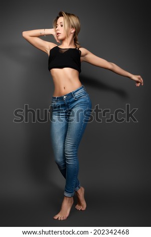 A photo of beautiful girl is in fashion style. The girl standing barefoot on the floor.