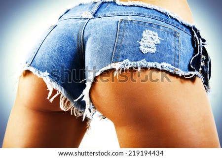 Sexy woman body in jean shorts. The model is back. Great ass. On a blue background.