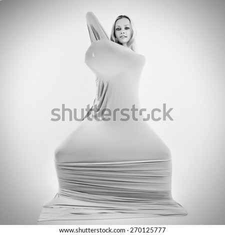 Art photo of a women silhouette breaking through the fabric.  Black and white photo