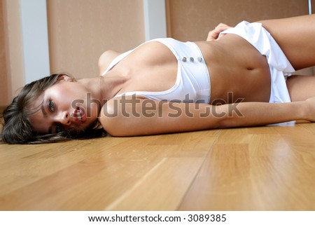 Naked woman lies on a wood floor.