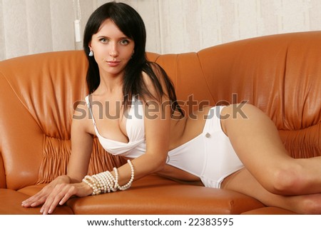 Glamour model poses on the leather sofa.
