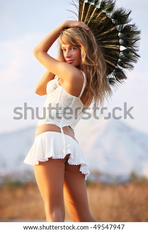 The young woman with a fan on a mountain background.